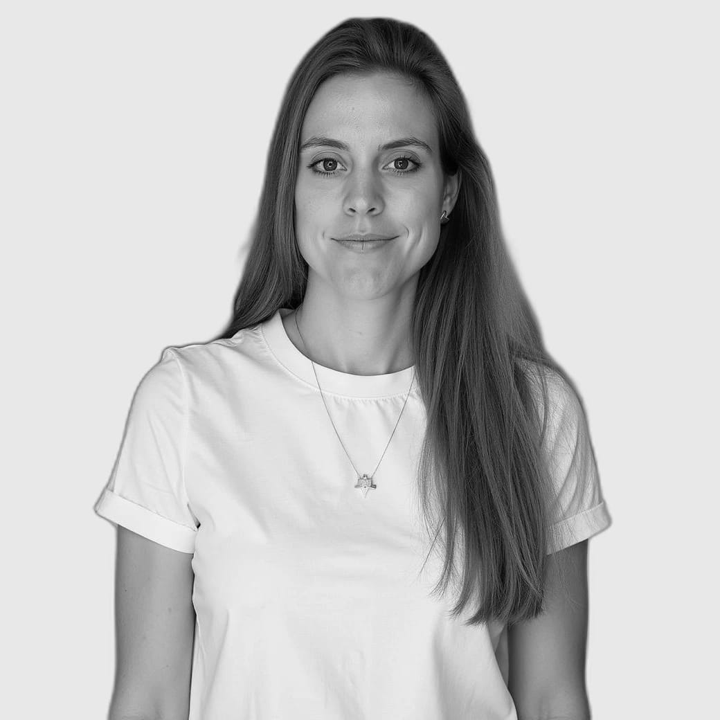 Portrait of a smiling woman with long hair wearing a white T-shirt and necklace.
