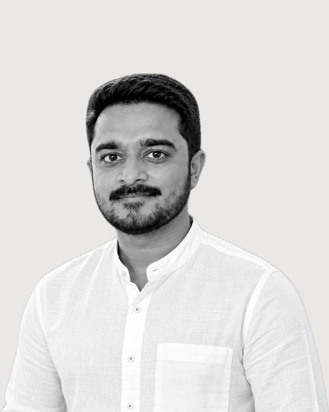 Portrait of a bearded man wearing a white shirt.