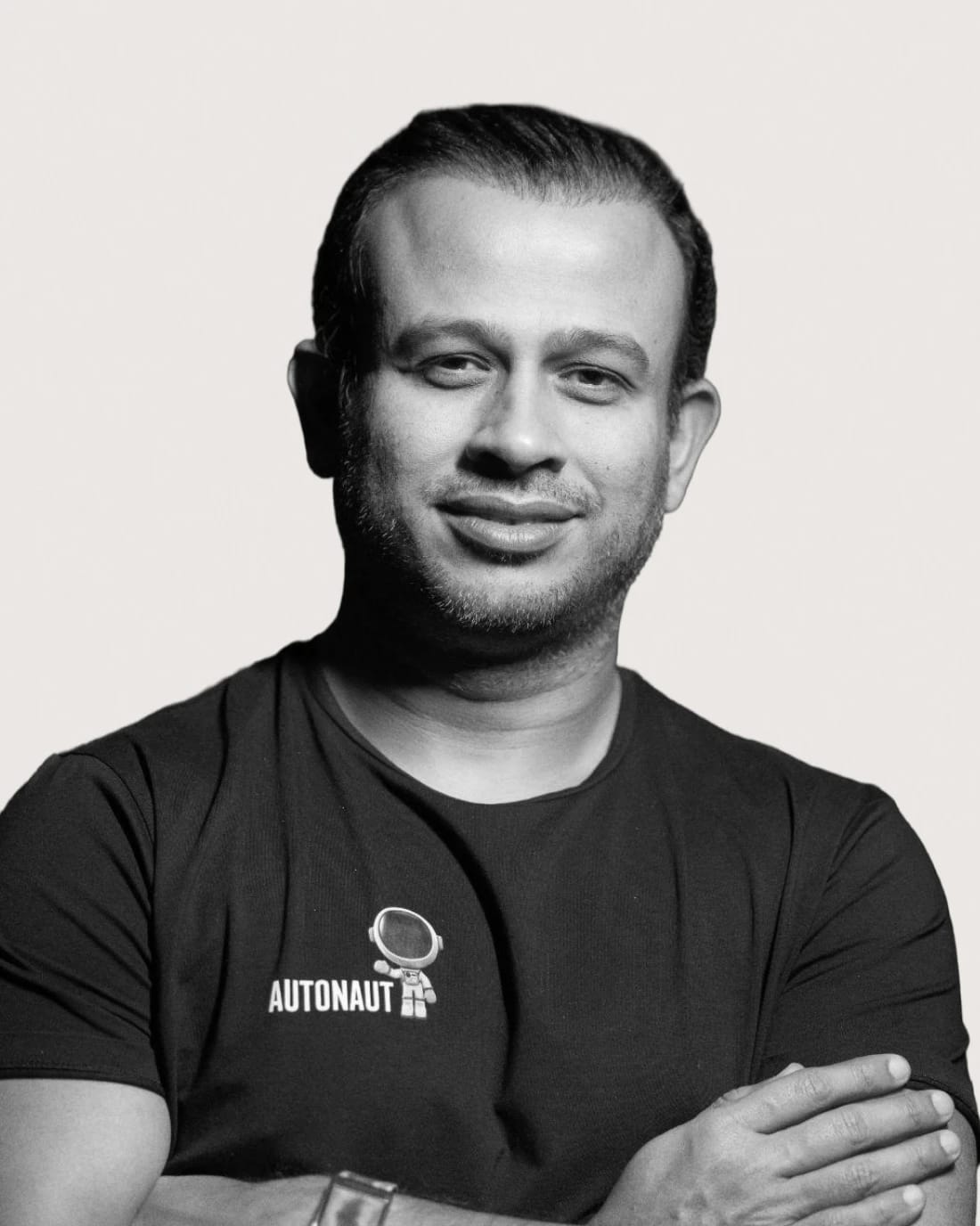 Black-and-white portrait of a man wearing an “AUTONAUT” T-shirt.