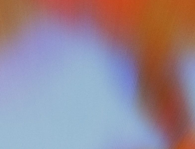 Abstract blurred gradient blending blue, orange, red, and purple tones.