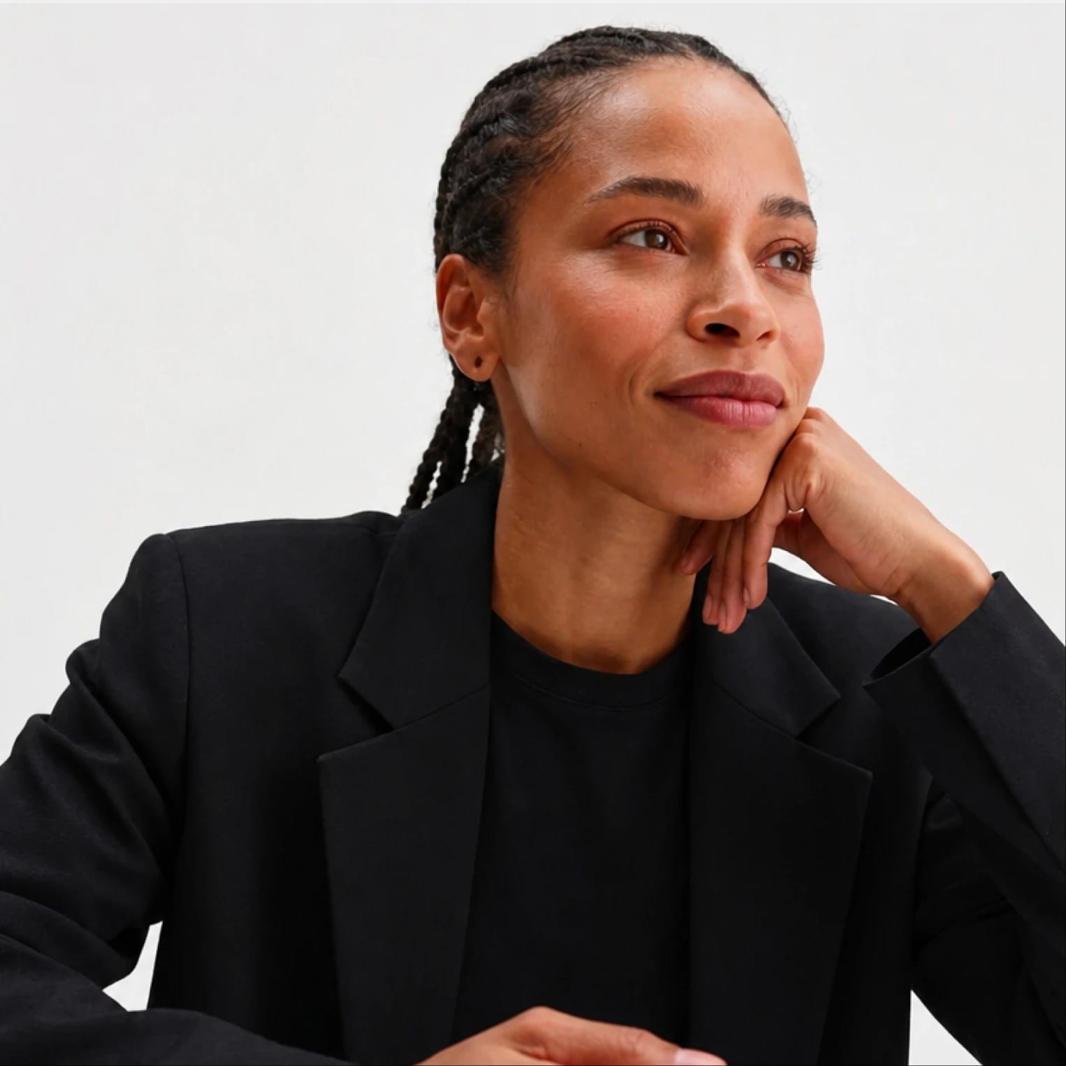 Professional woman in a black blazer looking thoughtfully to the side.