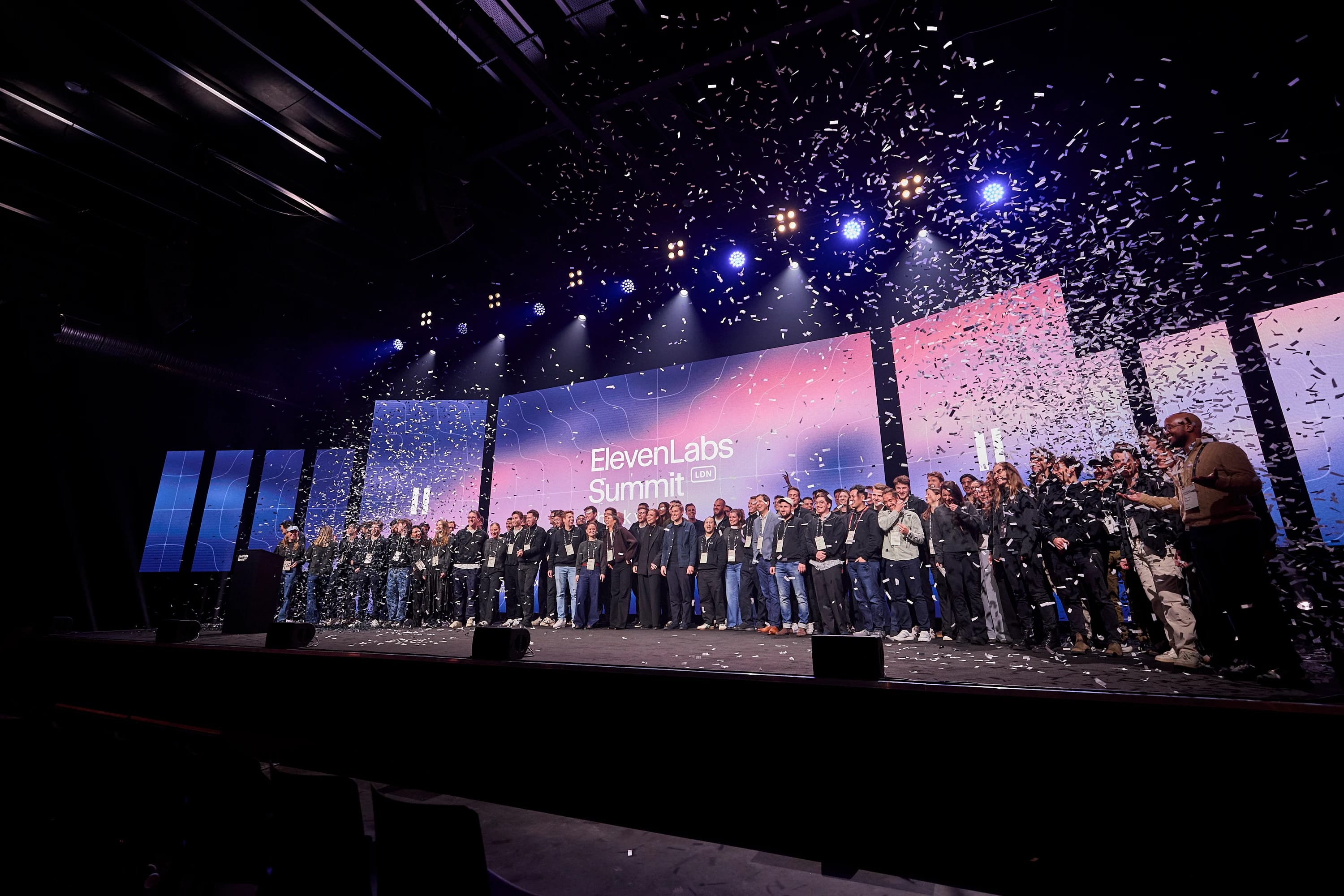 Group of people on stage at ElevenLabs Summit LDN with falling confetti.