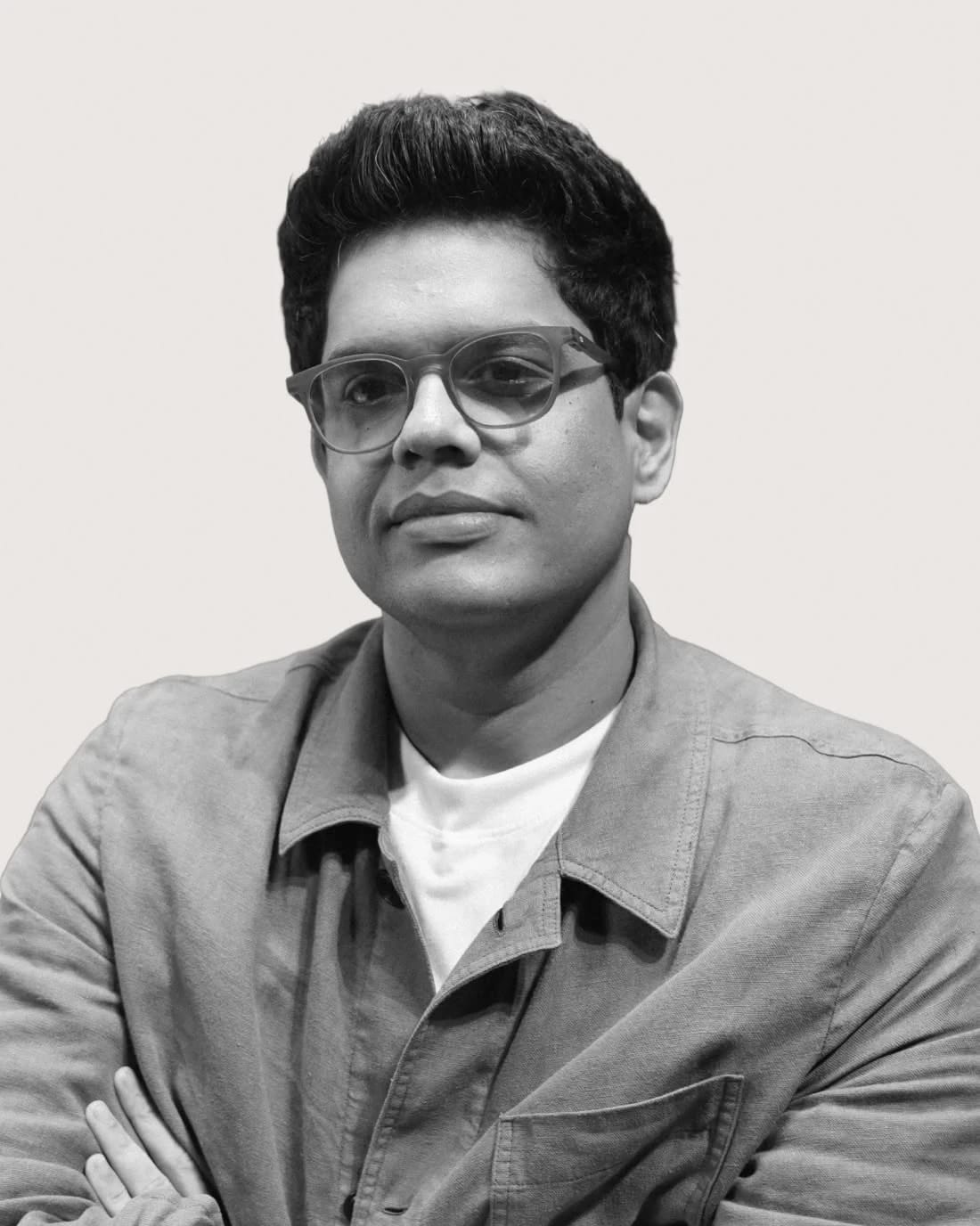 Portrait of a man wearing glasses and a work jacket.