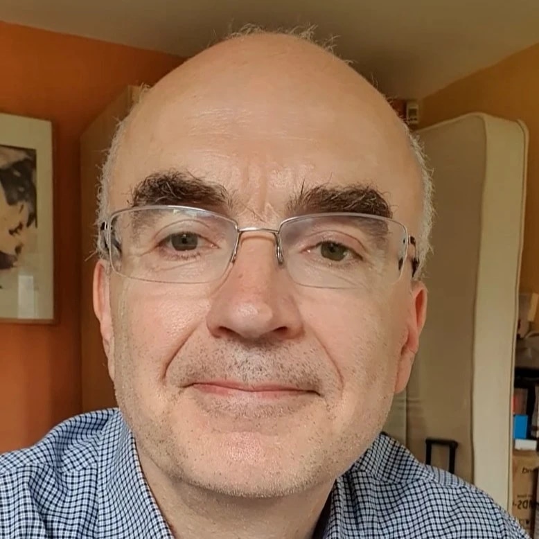 Man with glasses smiling at the camera
