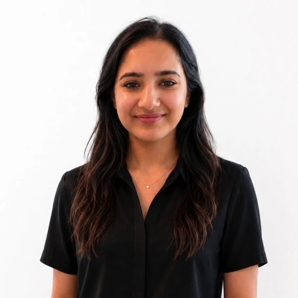 Smiling woman with long dark hair wearing a black blouse against a white background.