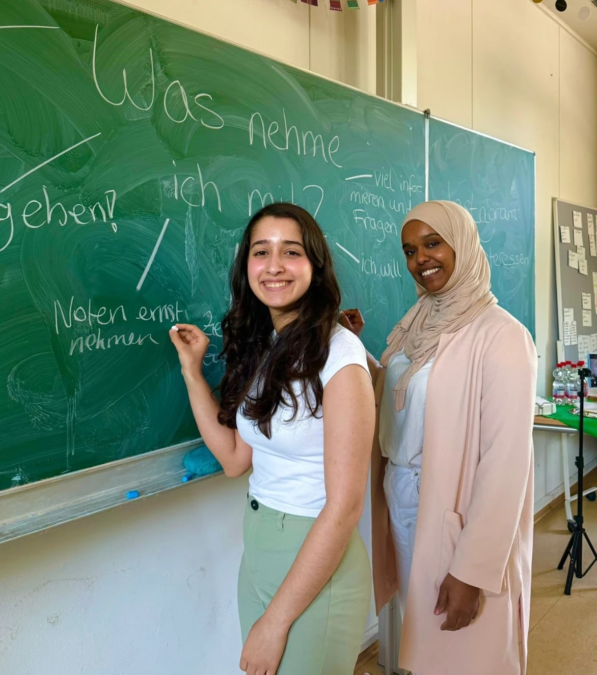 Two girls standing at a chalkboard