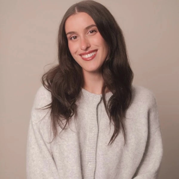 Smiling woman with long dark hair wearing a light gray cardigan.