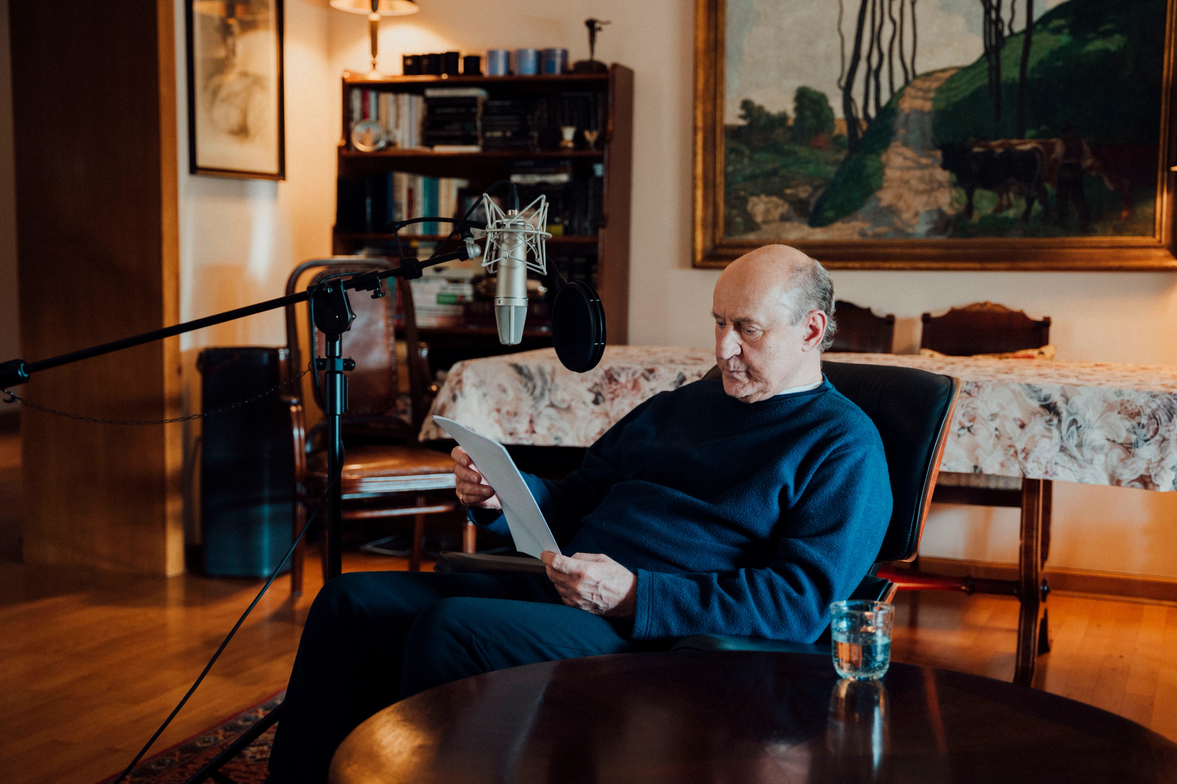 Piotr Fronczewski sitting in an armchair, studying a printed script