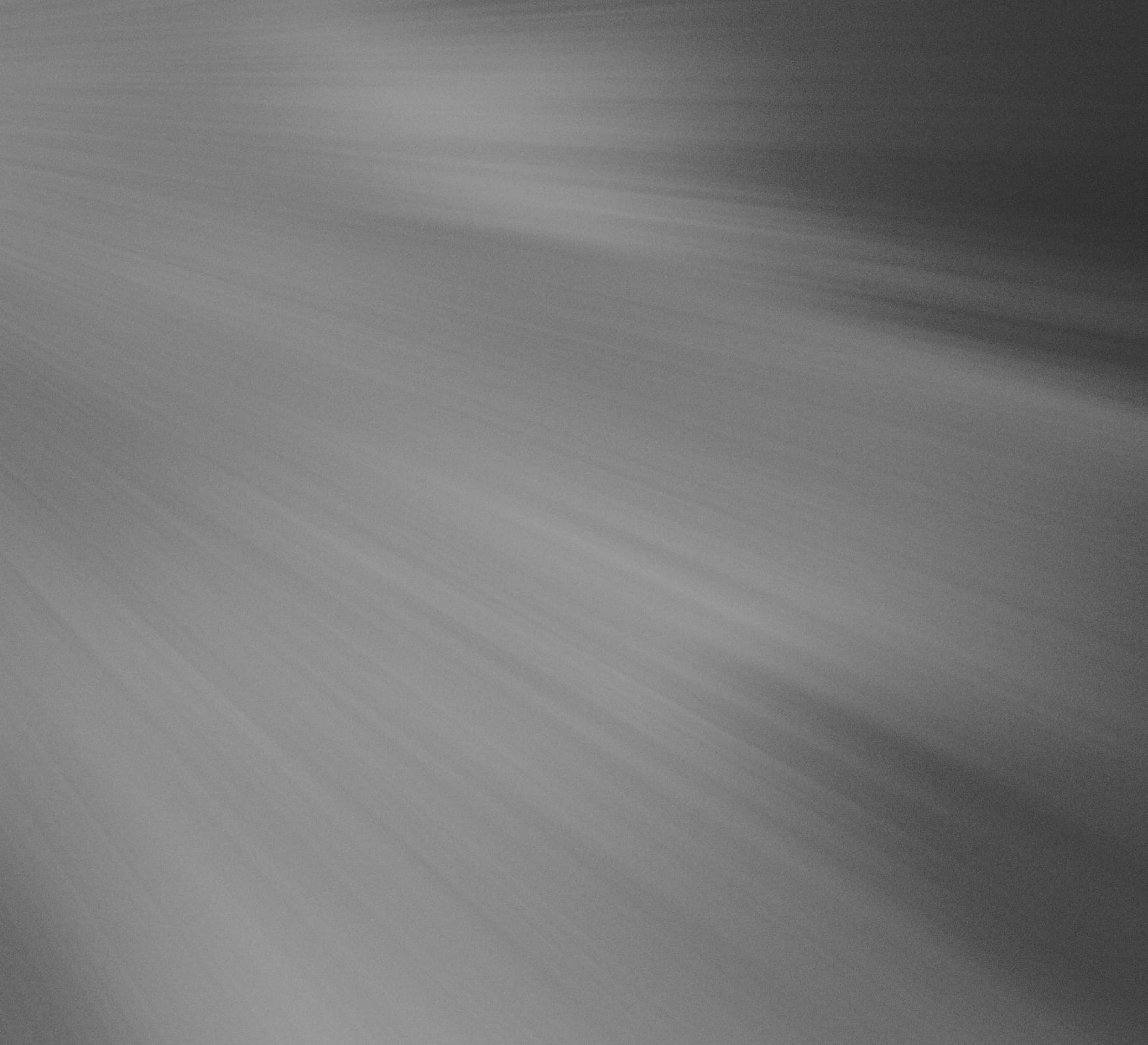 Abstract gray textured background with soft diagonal light and dark bands.