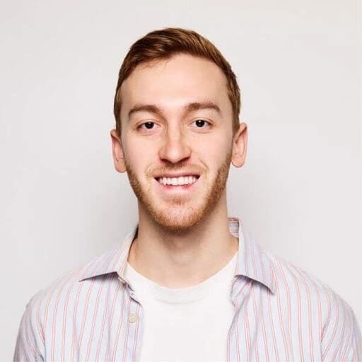 Smiling young man with short brown hair and a trimmed beard, wearing a striped shirt.