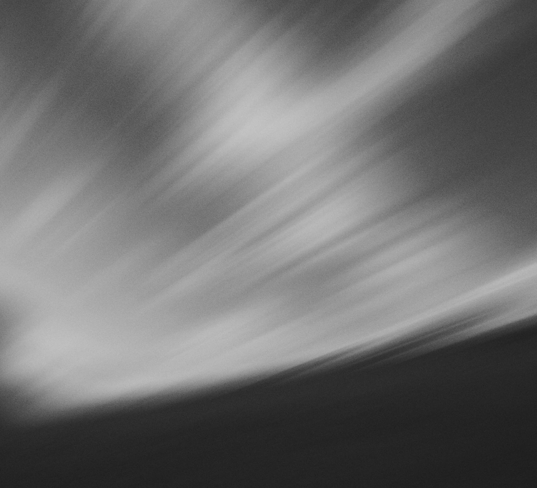 Abstract grayscale bands of soft light and shadow sweeping diagonally.